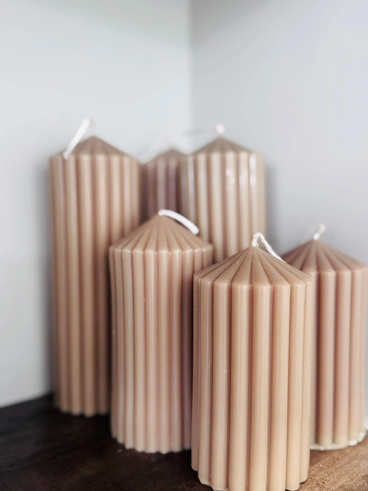 Nude Ribbed pillar-shaped candles.