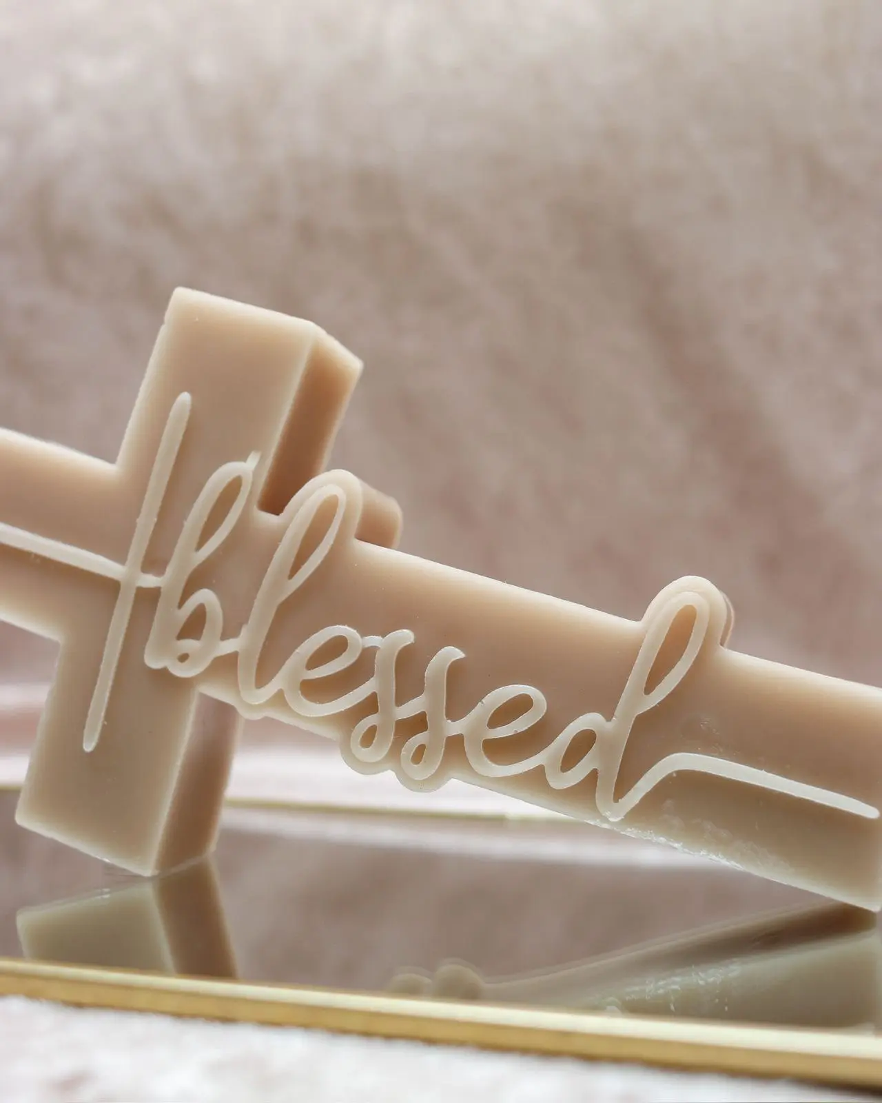 Nude candle of a cross with the word 'blessed' inside.