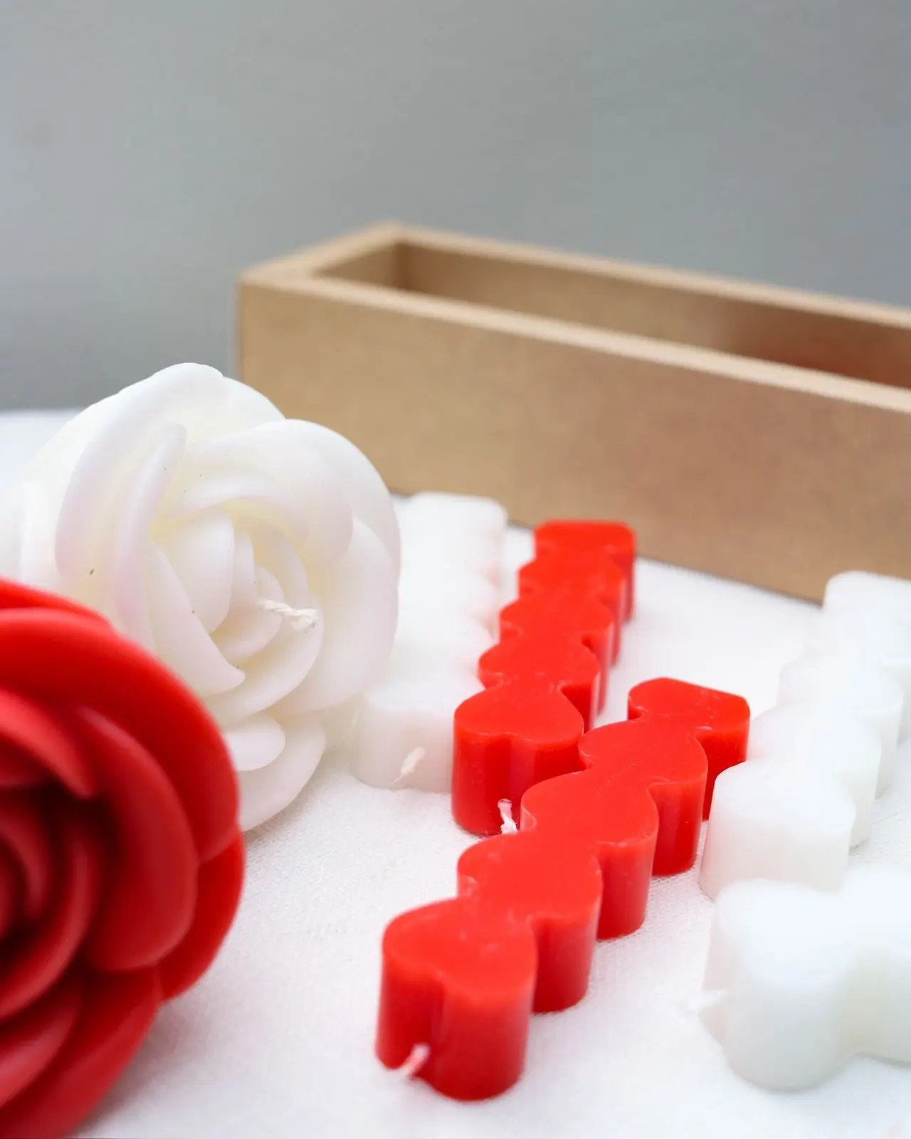 Candles of large red and white roses as well as stacked hearts.